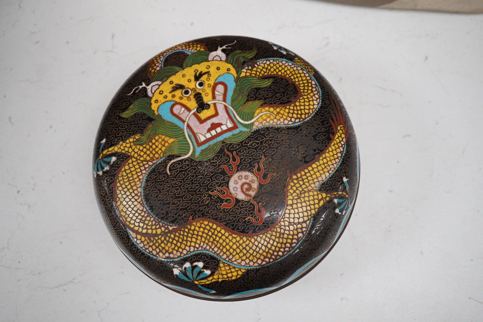 An early 20th century Chinese cloisonné enamel circular ‘dragon’ box and cover, 20cm diameter. Condition - good